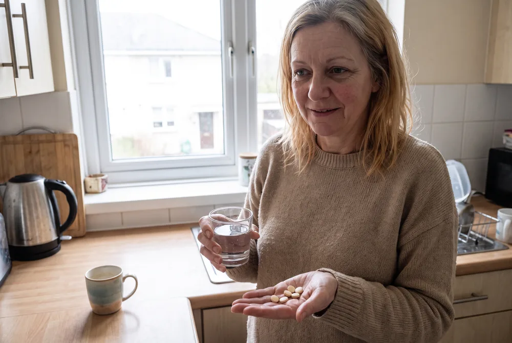 Frau nimmt Amino 8 in der Küche