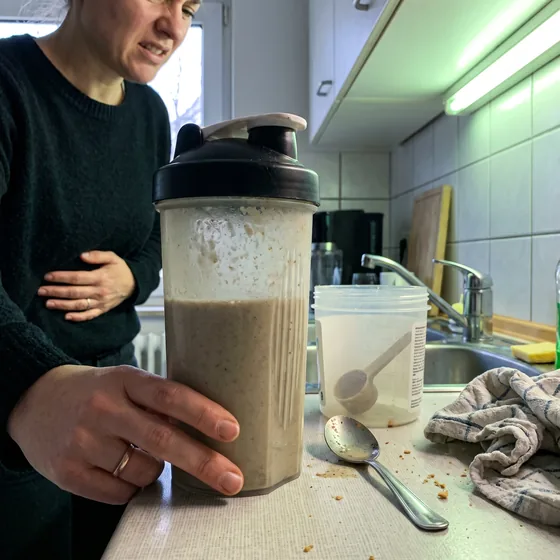 Frau mit Protein-Shake in der Küche
